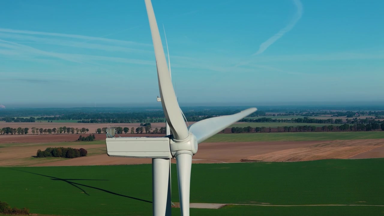 Vista aerea ravvicinata di pale eoliche sopra campi di energia rinnovabile.