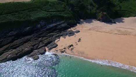 drone flying over sea waters along touesse beach, rozven, saint-coulomb in brittany, france. aerial drone top down forward