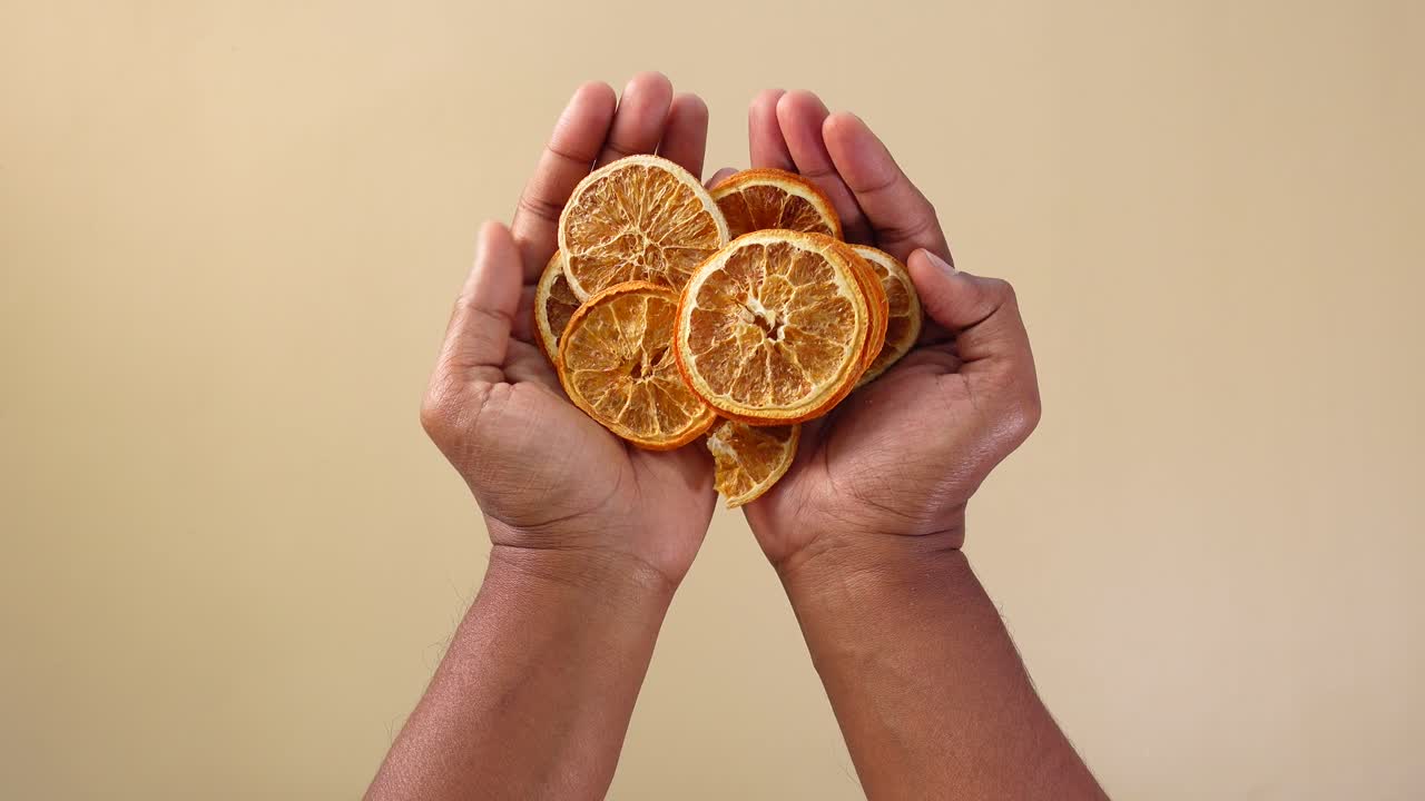 Hands holding dried orange slices