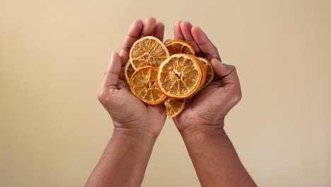 Hands holding dried orange slices
