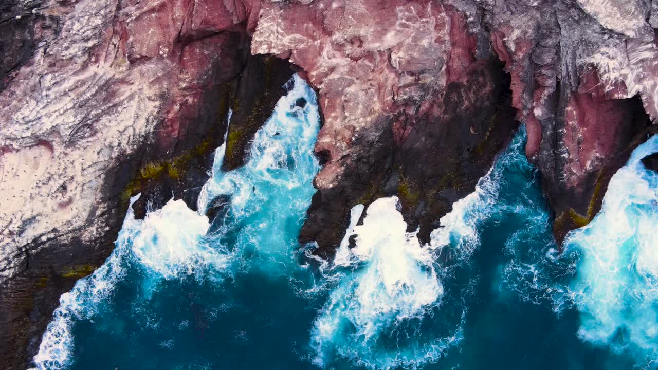 Aerial top down descends along the jagged cliffs of Coronado Islands, Mexico, showcasing the dramatic coastline and blue waters