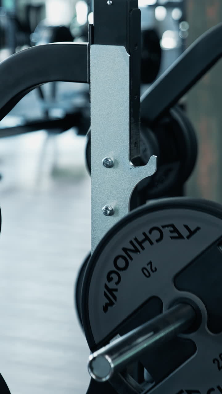 Bodybuilder Doing Barbell Exercise. Young man flexing muscles with barbell in the gym