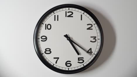 el reloj blanco se acerca en el lapso de tiempo en la pared blanca