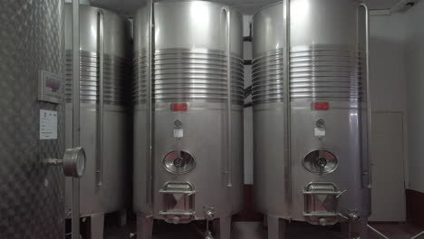 row of stainless steel fermenter tanks in a winery