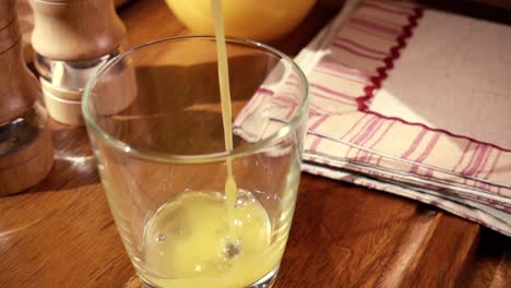 Jugo-De-Naranja-Vertido-En-Un-Vaso,-El-Desayuno-De-La-Mañana.-Cámara-Lenta-Con-Seguimiento-De-Rotación.