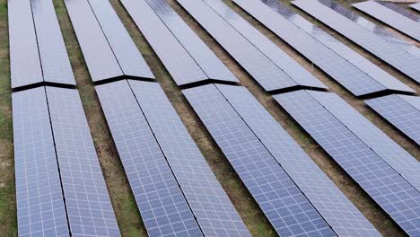 drone glides of solar panels, revealing detailed view of renewable energy fields