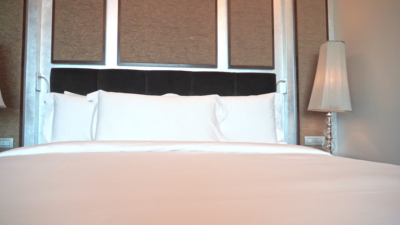 cacerola lenta a la izquierda en la cama tamaño king hecha con almohadas de lino blanco y cubierta en el hotel lasvegas