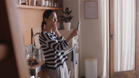 happy asian woman having video chat using smartphone at home chatting to friend enjoying conversation sharing lifestyle on mobile phone