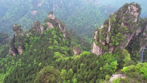 Aerial-tilt-up-shot-of-towering-karst-formations-in-Huangshizhai,-Zhangjiajie-National-Park,-China