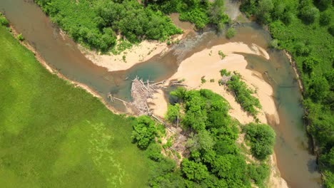 descending spiral shot of drying riverbed with a natural dam