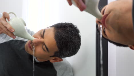 man using neti pot to clean his nasal passage