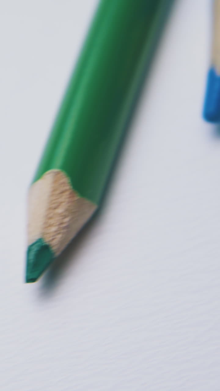 motion past different bright colored pencils lying on clean white background extreme close view