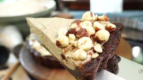 a delicious dessert, coffee hazelnut cream tart. made with espresso powder, chocolate crust and loaded with crushed hazelnuts. great with coffee. cutting a piece of pie and showing a close up shot