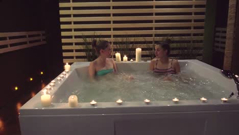 Two Women Relaxing in a Hot Tub with Candles