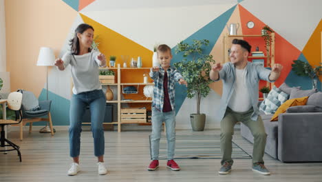 una familia feliz bailando en casa