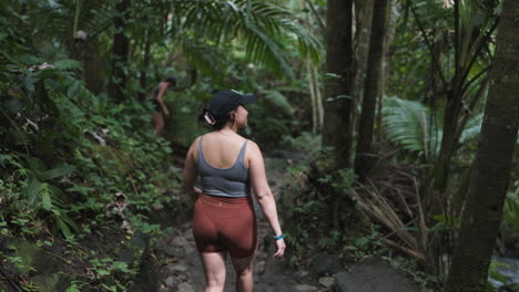 Slow-motion-shot-of-a-woman-hiking-through-the-dense-Puerto-Rican-jungle