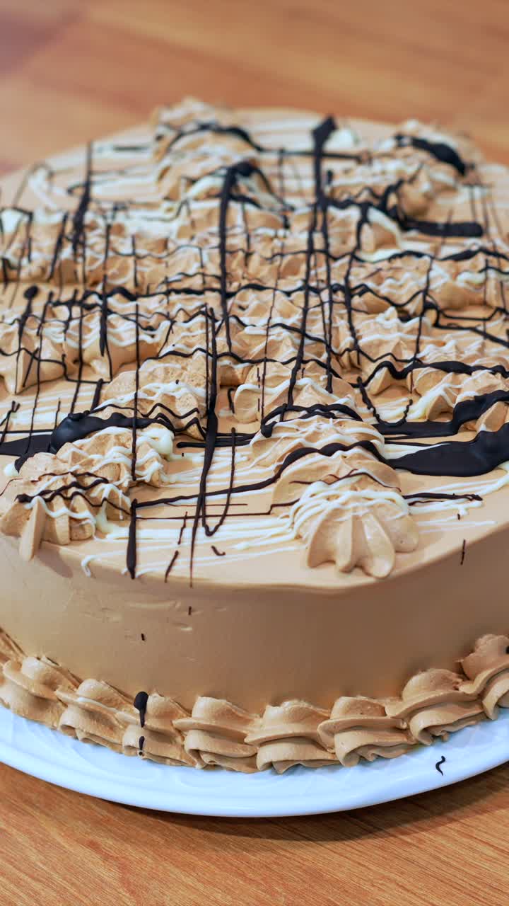 Torta gourmet con glassa al cioccolato a filo e decorazione a spirale.