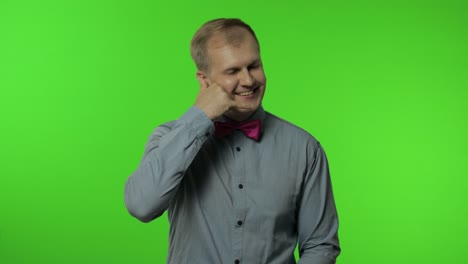 hola, llámame. hombre de pie con el teléfono gesto de la mano cerca de la cabeza y comunicarse, hablar por teléfono