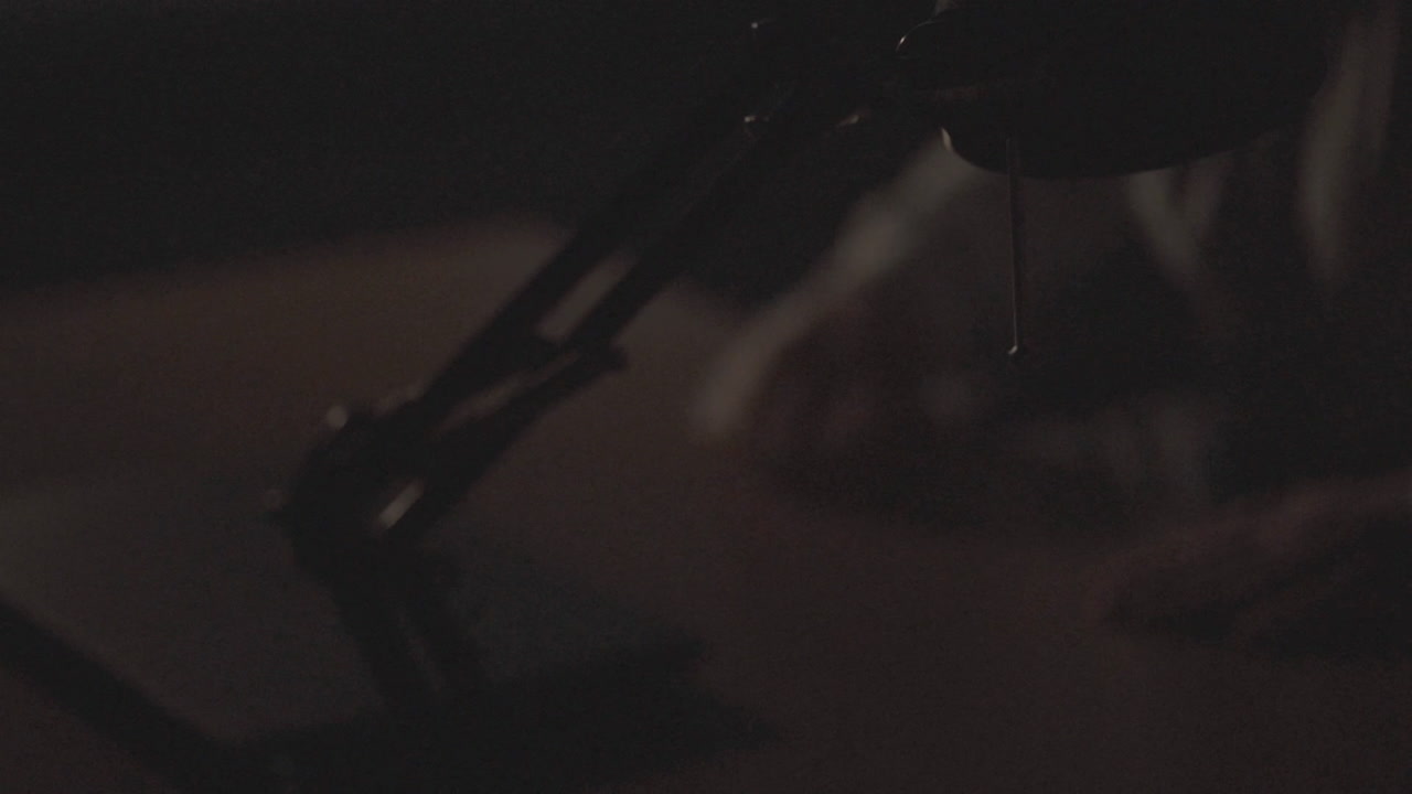 Person working late night at a desk with a laptop and desk lamp.