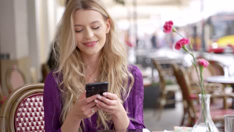 woman using phone in outdoor cafe