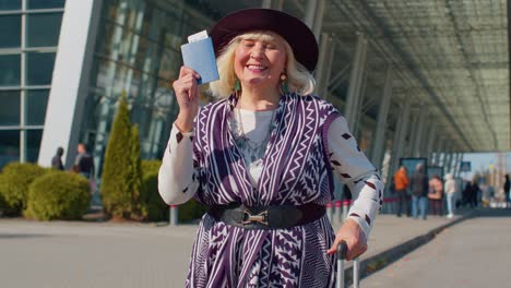 anciano pensionista turista abuela quedarse cerca de la sala del aeropuerto celebrar el éxito ganar ganador gesto