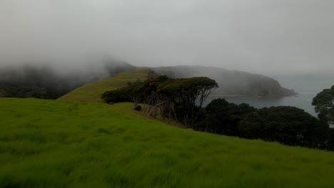 drone flying on mountain hill with misty landscape of rangihoua and wairoa bay at purerua peninsula in bay of islands, northland, new zealand