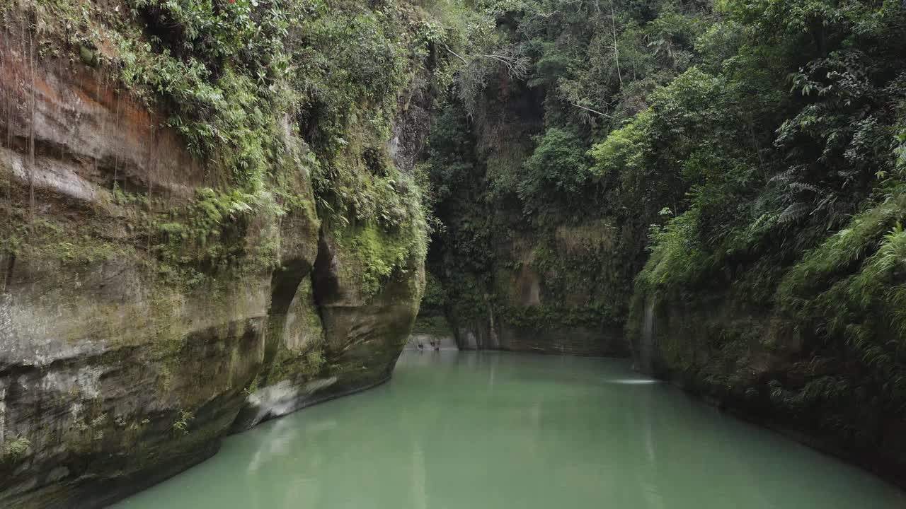 cañón guejar, en mesetas colombia, aguas cristalinas, aguas verde esmeralda, sobrevuelo a baja altura, con grandes piedras