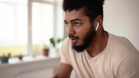 Close-up-of-good-looking-mixed-race-man-training-in-active-boxing-punches-during-home-workout