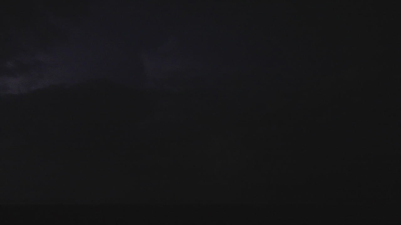 Flashes of lightning light up the nighttime sky in fast motion clip
