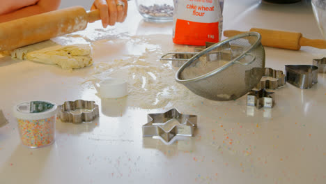 Front-view-of-young-Caucasian-mother-and-daughter-rolling-dough-in-kitchen-of-comfortable-home-4k