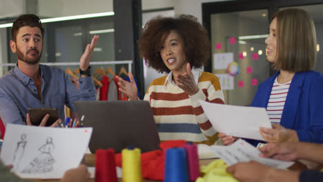 Mixed-race-colleagues-sitting-in-office-and-discussing-work-over-laptop