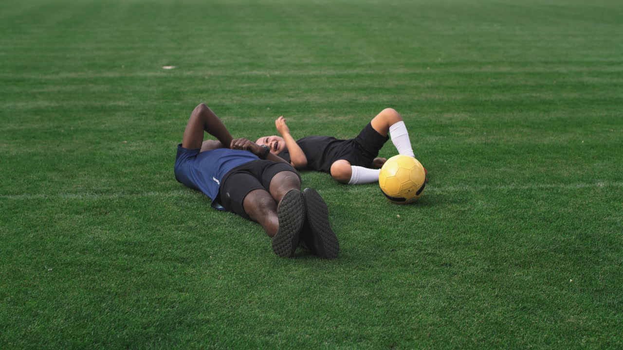 Father and son resting on a soccer field