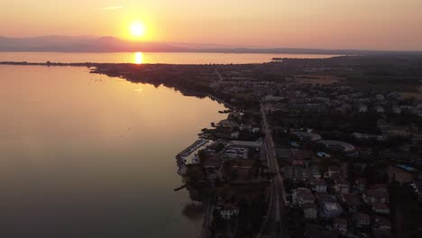 Aerial-shot-of-Lake-Garda-at-sunrise-with-mountains-in-the-back