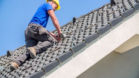 professional male roofer preparing roof tiles for solar panel construction