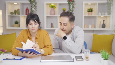 Thoughtful-couple-holding-notebook.