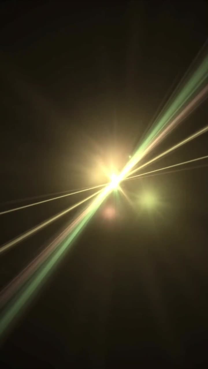 Raggi di luce dinamici verdi e gialli con effetto lens flare su sfondo nero