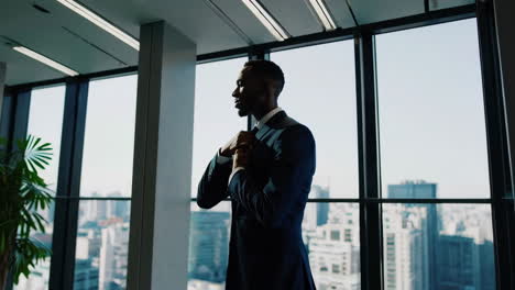 businessman adjusting tie in modern office