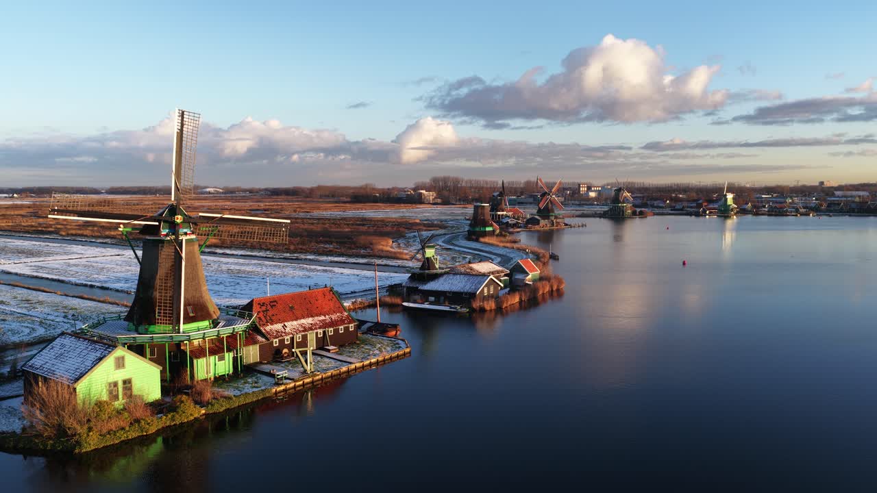 Luftaufnahme der Zaanstreek-Windmühlen im Winter bei Zaanse Schans, die historische Polder-Mühlen, eine Schneelandschaft und das niederländische Kulturerbe zeigt