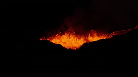 erupción volcánica efusiva con salpicaduras de magma líquido durante la noche