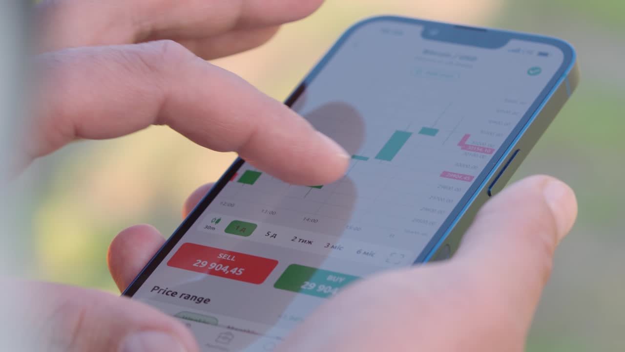 hombre de 4k mira el gráfico de velas de comercio de criptomonedas en la pantalla de su teléfono inteligente