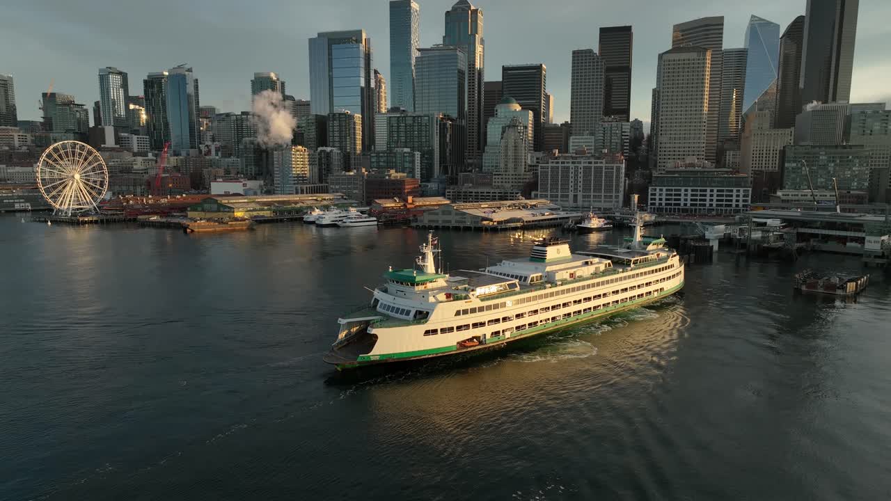 Vehicle ferry prepares to dock at pier on the Seattle waterfront at dawn, aerial