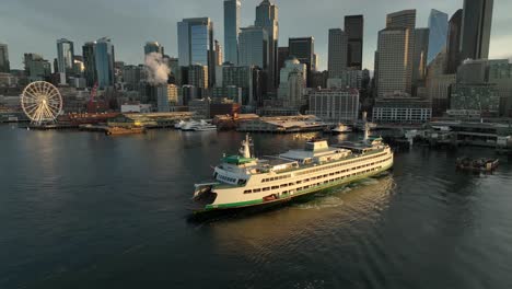 vehicle ferry prepares to dock at pier on the seattle waterfront at dawn, aerial