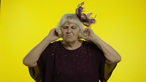 molesta irritada anciana senior cubriendo las orejas y gestando no, evitando consejos, ignorando el ruido