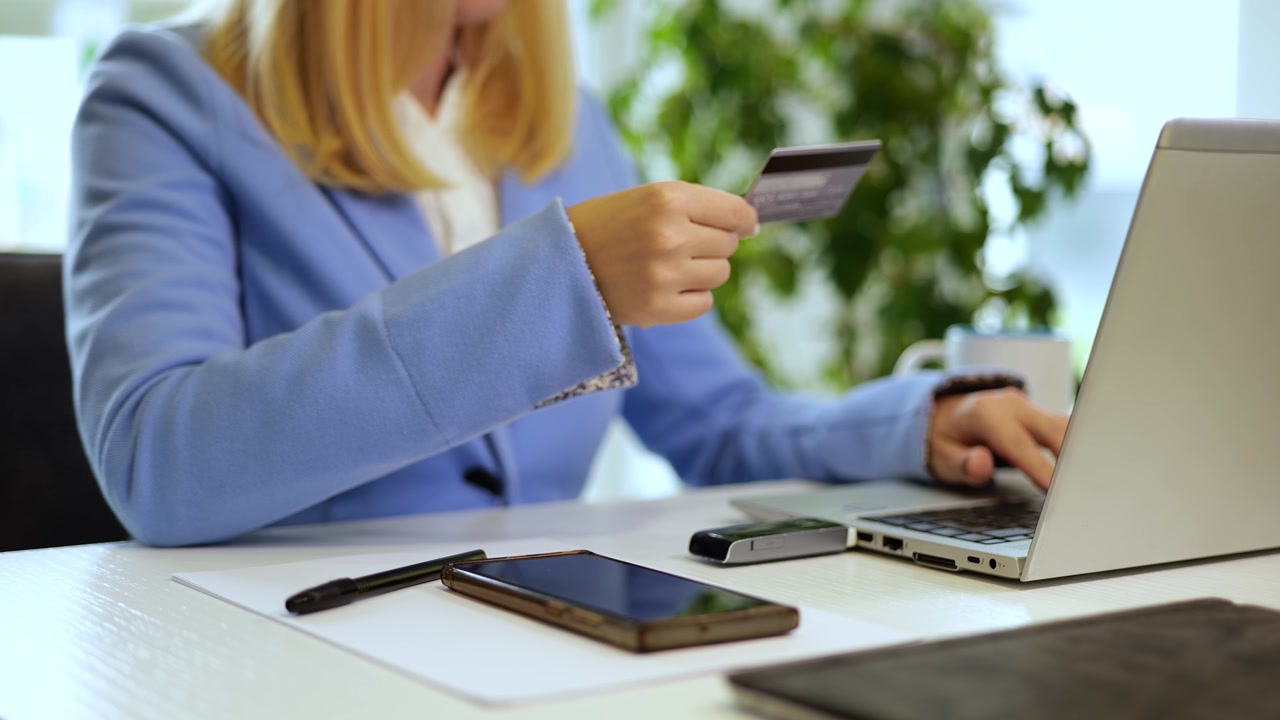 Donna d'affari che usa la carta di credito nel suo ufficio per un pagamento online sicuro via internet