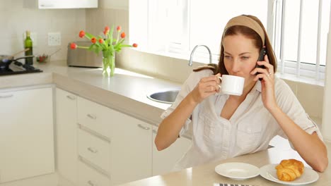mujer bonita hablando por teléfono en el desayuno