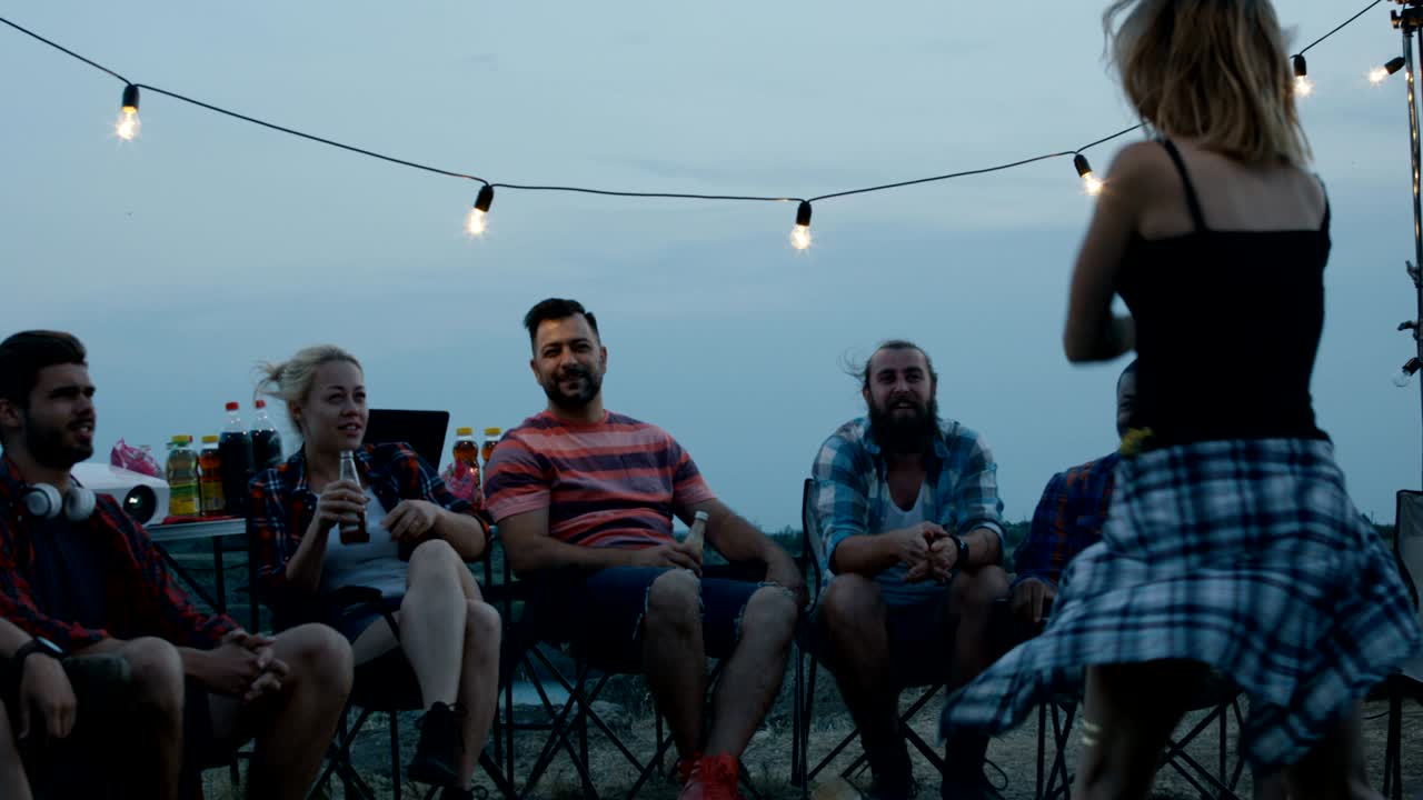 Laughing diverse friends playing charades in camp