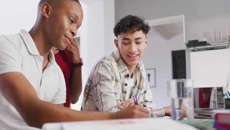 tres felices y diversos amigos adolescentes escribiendo y hablando en casa, en cámara lenta