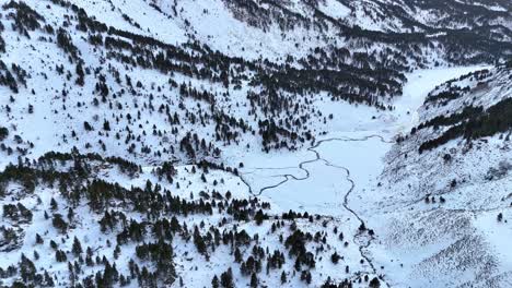 Drohnenaufnahmen-Eines-Verschneiten-Tals-Mit-Einem-Zugefrorenen-Fluss-In-Den-Pyrenäen