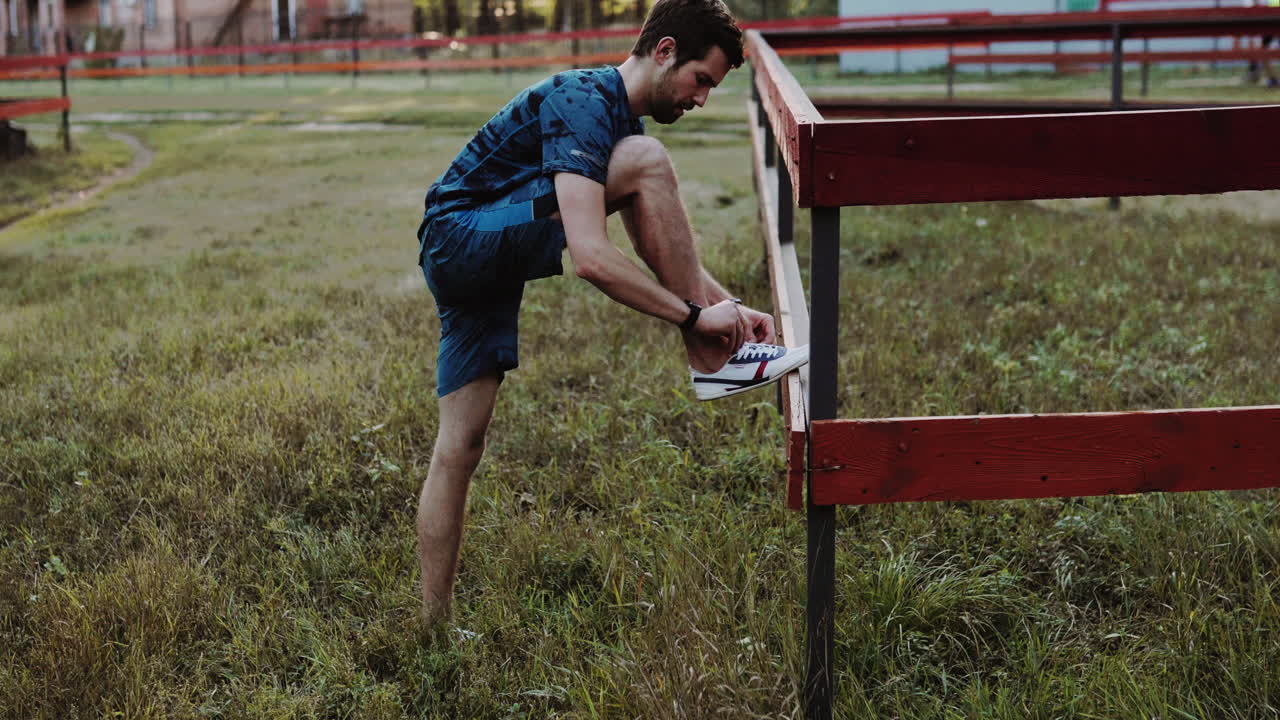 hombre atando cordones de zapatos al aire libre