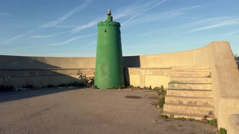 An-industrial-complex-featuring-green-tinted-water-silos,-situated-along-the-Spanish-coastline,-exemplifying-the-harmony-between-man-made-infrastructure-and-coastal-ecosystems